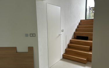 Dveře SAPELI Elegant Premium bílá ve skryté zárubni JAP, černá klika Grifwerk